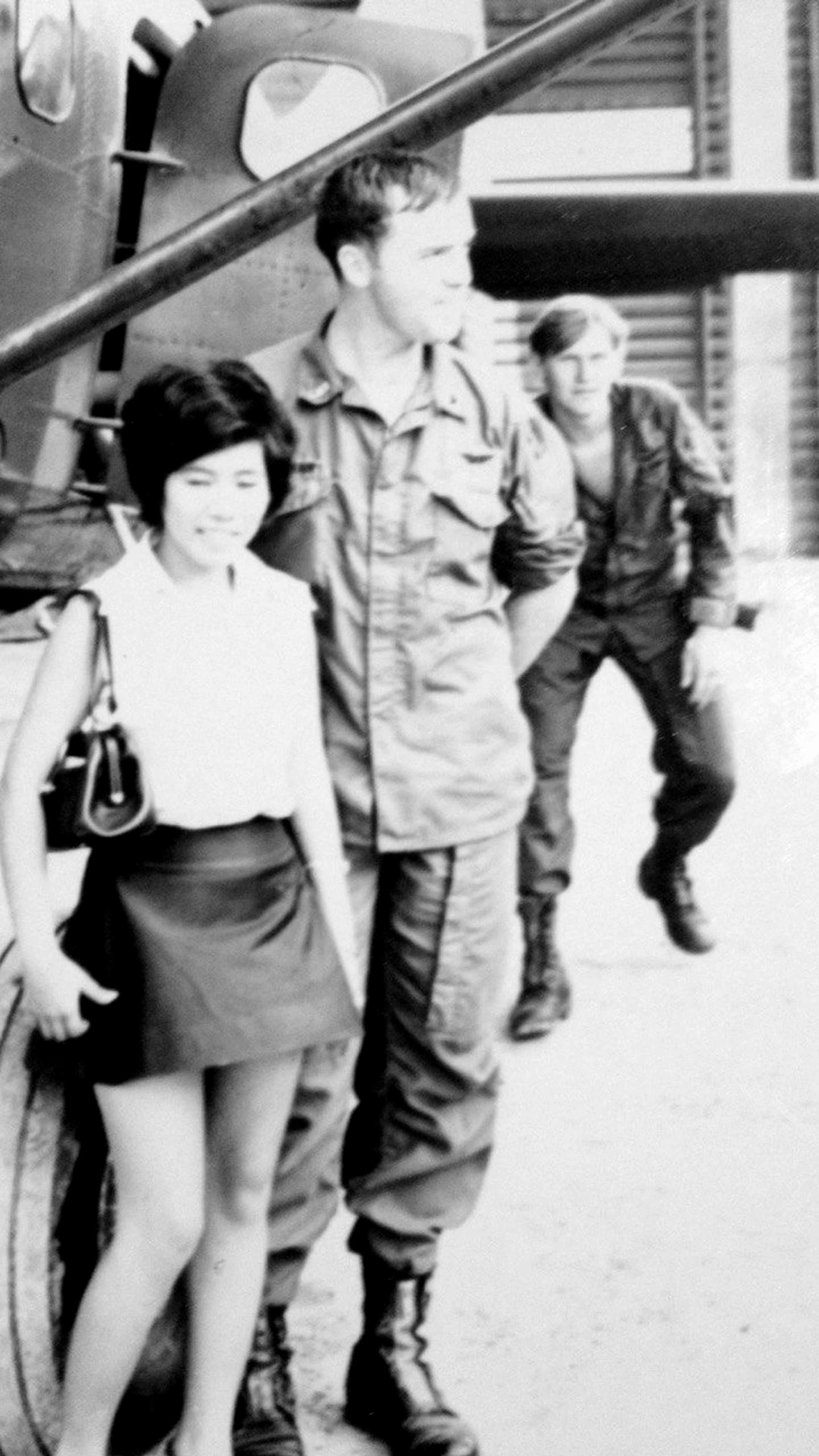 Del and Paula walking together beside a military aircraft